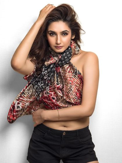A creative studio shot of Ragini Dwivedi for a magazine's birthday edition. The use of a patterned scarf as a top creates a dynamic and visually interesting portrait.