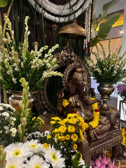 A close-up of the beautifully decorated Ganesha idol, showcasing the intricate details and the freshness of the floral arrangements.