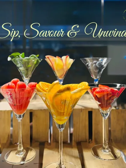 A beautiful display of martini glasses filled with a rainbow of fresh fruit garnishes, from watermelon and orange to strawberries and mint. We believe in using the best ingredients to build our drinks.