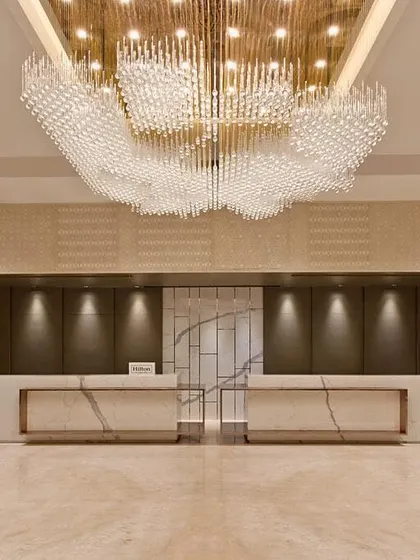 The lobby of a hotel is the first chapter of its story. Here, I designed a grand, welcoming space using a massive, cloud-like chandelier as the focal point. This is supported by precisely aimed downlights that accentuate the marble reception desks, ensuring the space is both awe-inspiring and functional.