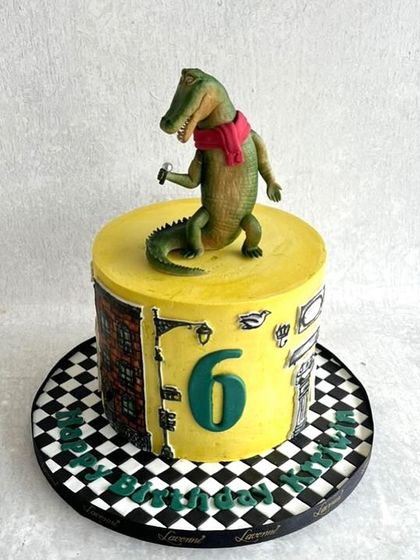 A fun cake based on the book "Lyle, Lyle, Crocodile." We recreated the character and a city scene on the side of the cake.