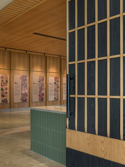 A detailed shot of the custom-designed doors leading into the lobby. The combination of dark-stained and natural wood in a grid pattern adds a touch of craftsmanship and graphic interest.