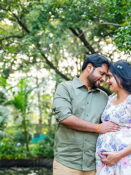 An intimate portrait of the couple, forehead to forehead, sharing a quiet moment of anticipation in a beautiful, sunlit garden.