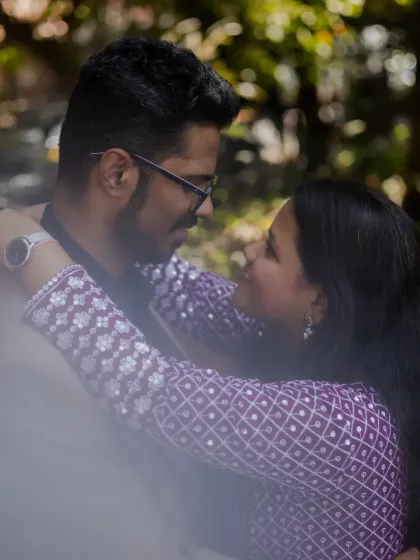 A close-up, intimate portrait of the couple looking into each other's eyes, framed by a soft foreground for a dreamy effect.