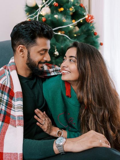 Romanticizing Christmas. A cozy moment for a couple, wrapped in a plaid blanket by the tree.