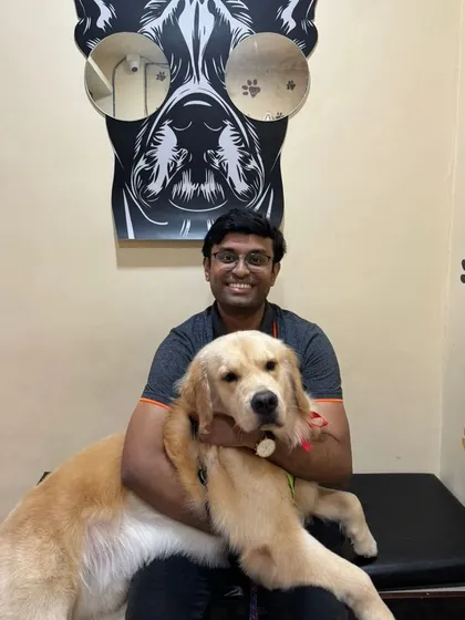 A happy pet parent cuddles his freshly groomed Golden Retriever in our salon's waiting area.