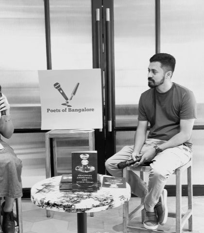 A black and white shot capturing a serious moment of discussion between the author and host, adding an artistic and timeless feel to the gallery.