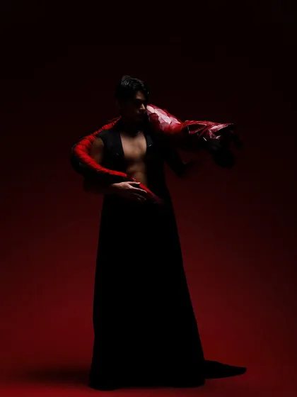 A dramatic, low-light shot of a male model from the "Yume" editorial, with subtle smokey eye makeup enhancing the mood.
