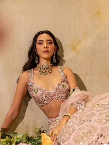 A relaxed, artistic shot that still highlights the beauty of the jewellery and the mirror-work on the lehenga.