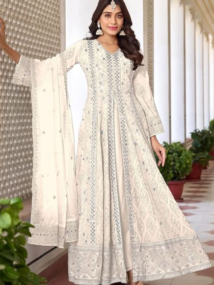 An ethereal white Anarkali suit that's perfect for any special occasion. The heavy thread, zari, and sequence work give it a divine glow.