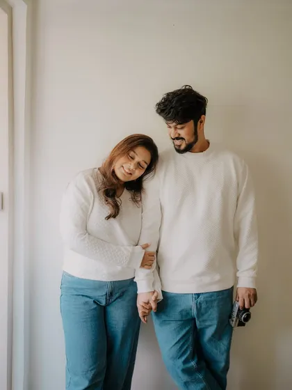 A sweet and simple pose from an indoor session. Her head on his shoulder and their hands intertwined convey a sense of comfort, trust, and quiet love.