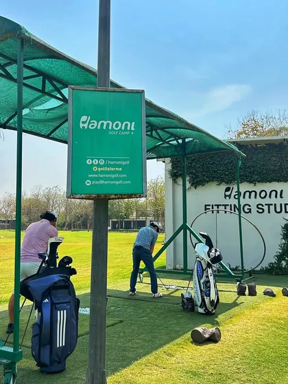 Two golfers practice near our Fitting Studio, a reminder that we have the tech to help you improve.