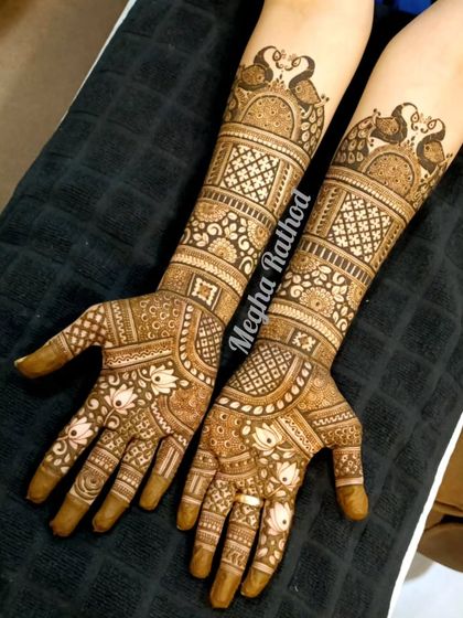 A lovely semi-bridal or engagement design that is rich in detail. It features peacock motifs on the arms and a mix of lotus and geometric patterns on the hands.