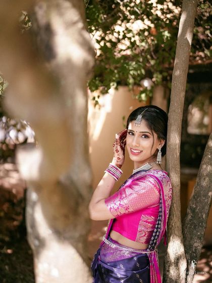 A sweet portrait of the bride smiling by a tree, her happiness evident.