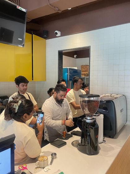 Perfecting the basics is crucial. Here, I'm demonstrating proper tamping technique, a fundamental step in achieving a balanced espresso shot, during a staff training session.