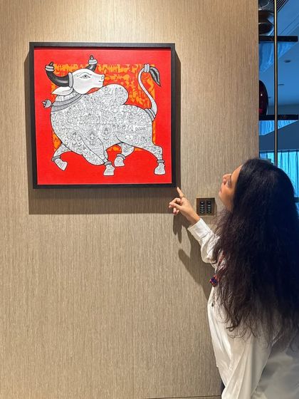 Art should tell a story. This hand-painted canvas, with its bold red background and traditional Indian bull motif, adds a powerful pop of color and culture to this contemporary space.