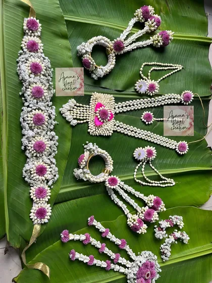 A full floral jewellery set in white and purple. This shows a kamarband, necklace, hath phool, and other pieces that can be created for various festive occasions.