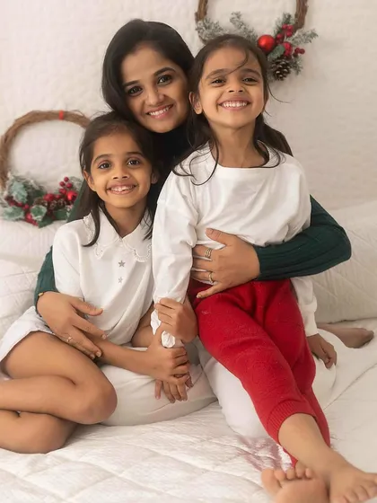 A mother and her two daughters sharing a beautiful moment. The composition highlights their close-knit relationship and individual smiles.