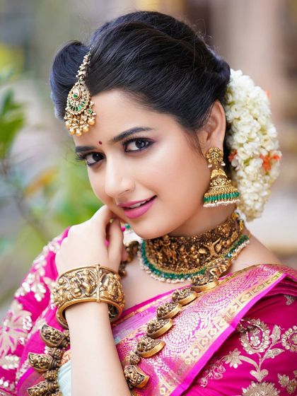 A direct and engaging portrait of Ashika Ranganath, highlighting her expressive eyes and the beautiful craftsmanship of her choker and jhumkas.