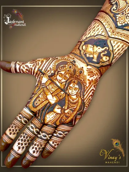 For a touch of divine love, I specialize in mythological artistry. This detailed palm design features a beautiful portrait of Radha and Krishna, surrounded by fine-line fillers and a traditional elephant motif on the wrist.