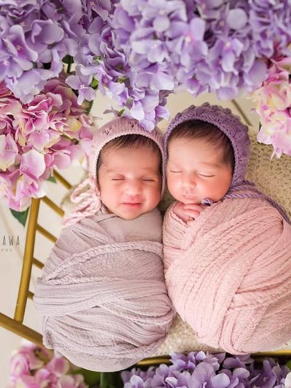 Sweet dreams, little ones. Dressed in coordinating bonnets, these twin girls are sleeping peacefully side-by-side. Capturing twins requires special care and patience to get these perfect moments.