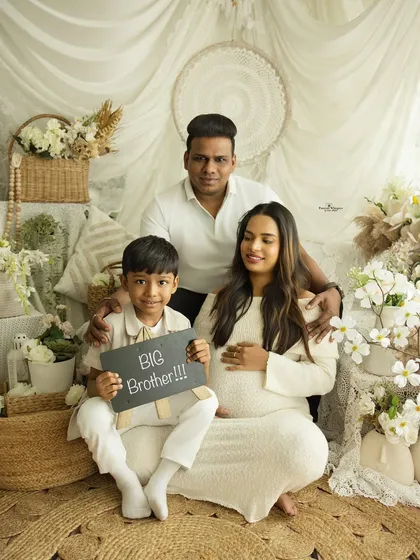 "Big Brother!" This proud older sibling announces his new role in a fun and heartwarming family portrait. It's a perfect way to include the whole family in the maternity journey.
