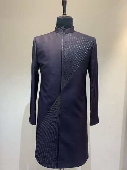 This longline Indo-western jacket in a deep navy features an asymmetrical splash pattern of hand embroidery, creating a modern and artistic silhouette.