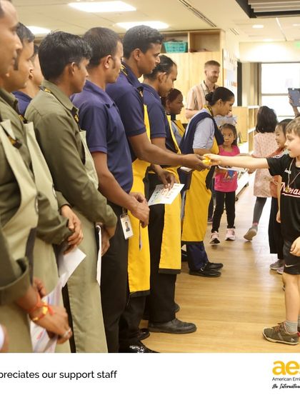 A kindergartener presents a thank you card and a cookie to a member of our custodial staff. This event teaches our youngest learners the importance of gratitude and recognizing everyone who contributes to our community.