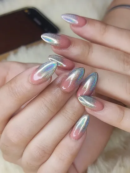 Holographic chrome is perfect for when you want your nails to truly stand out. This look features a beautiful ombré blend from a natural pink base to a dazzling silver holographic chrome tip on almond-shaped extensions. The way it catches the light is just incredible.