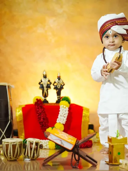 A full-length portrait of the little Varkari, standing with his musical instruments and the idols of Vitthal and Rakhumai in the background.