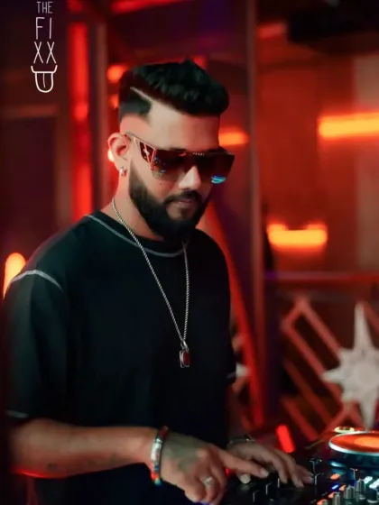 Another angle of me focused on the mix, wearing stylish shades that are part of my signature look.