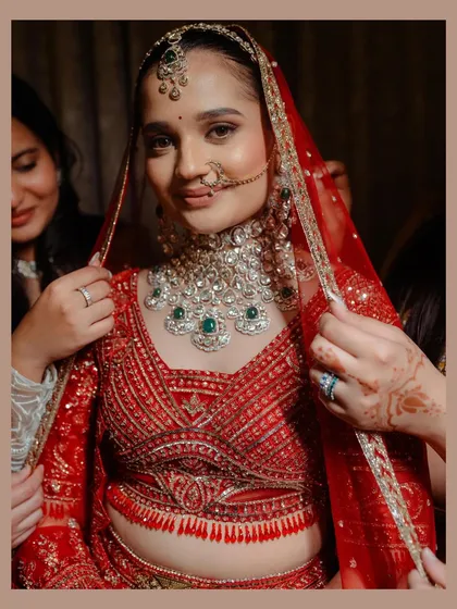 The final adjustments before she walks down the aisle. This close-up highlights the intricate beadwork of her Falguni Shane Peacock blouse and the stunning diamond and emerald necklace, all part of the complete bridal look I helped style.