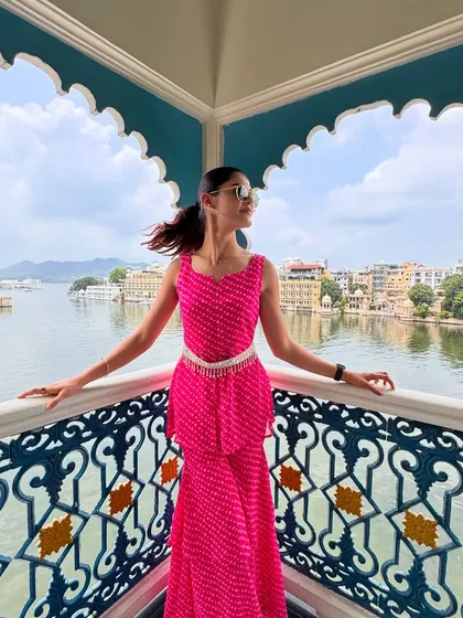 Styling for a vacation is about matching the energy of the place. For this trip to Udaipur, I chose a vibrant pink bandhani co-ord set that felt both festive and modern. The peplum top and tiered pants, paired with a traditional silver belt, created a look perfect for exploring the city's beautiful architecture by the lake.