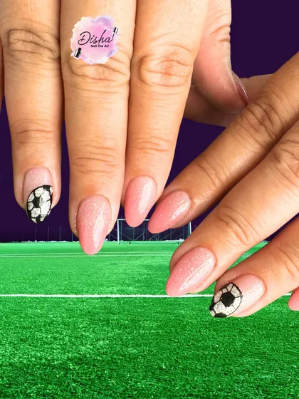 For the football fans. This fun set features a shimmery pink base with hand-painted soccer balls on the accent nails, combining sporty and chic.