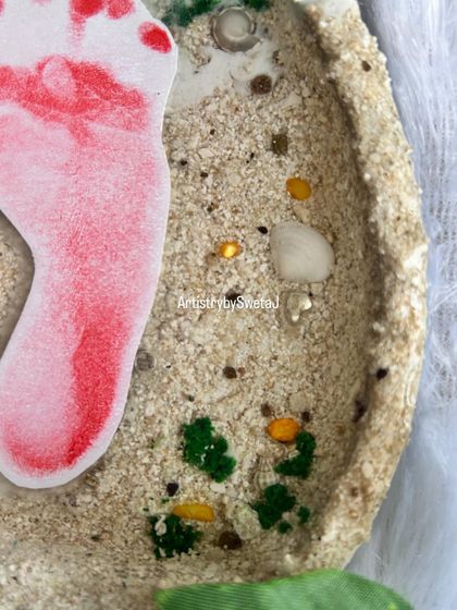 A close-up of the sandy beach texture I create in my baby keepsakes. I use real sand and tiny shells to give it an authentic feel, a perfect base for preserving those tiny footprints.