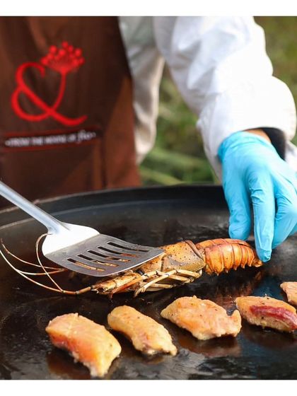 A close up of fresh lobster and salmon being expertly grilled on a flat top tawa. This showcases the premium ingredients we use at our live seafood stations, a luxurious addition to any brunch or evening event.
