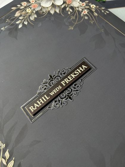 Quality is in the details. This close-up shows the raised, glossy finish of the couple's names on the nameplate, set against the matte texture of the box. It’s this attention to detail that makes my invitations feel truly premium.