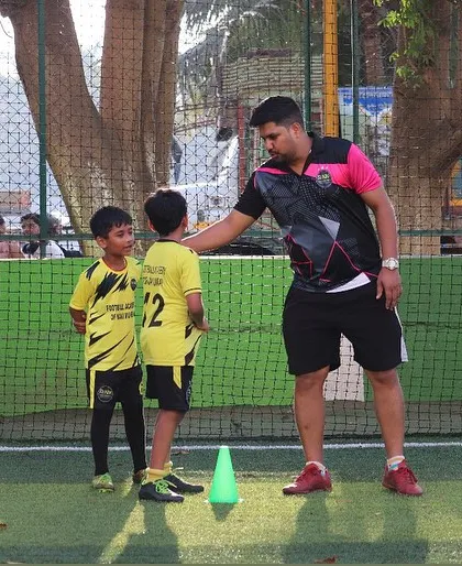 A coach offers a word of encouragement to two young players, building their confidence.