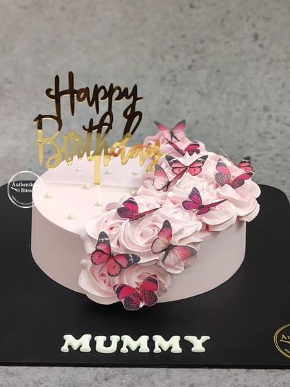 A beautiful butterfly cake for a mother's birthday. A cascade of pink buttercream roses is adorned with a flight of delicate pink butterflies.