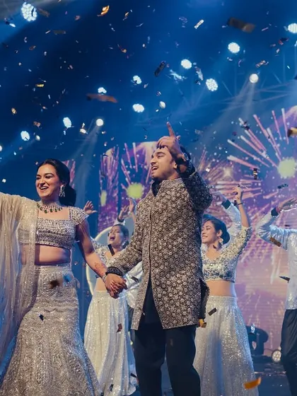 The perfect end to a perfect performance. This finale shot captures the pure joy of the couple surrounded by their loved ones, with a confetti blast that marks the peak of the celebration. It's these moments of shared happiness that we live for.
