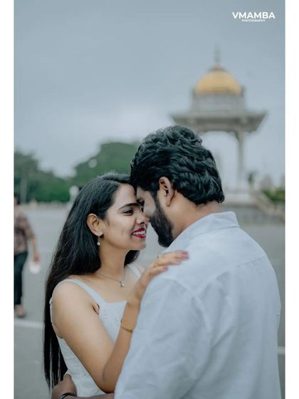 A close-up, romantic shot of a couple in front of a monument in Mysore. This highlights their connection while still giving a sense of the grand location.