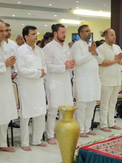 Participants, including international guests, stand together in prayer during a session in Kashmir. The serene environment of the valley enhances the meditative and devotional experience.