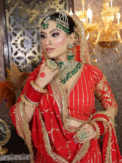 The bride adjusting her jewelry, giving a clear view of the intricate necklace and earrings.