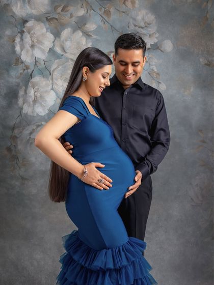 This couple chose a stunning royal blue gown and a painted floral backdrop for their session, creating a rich and artistic portrait.