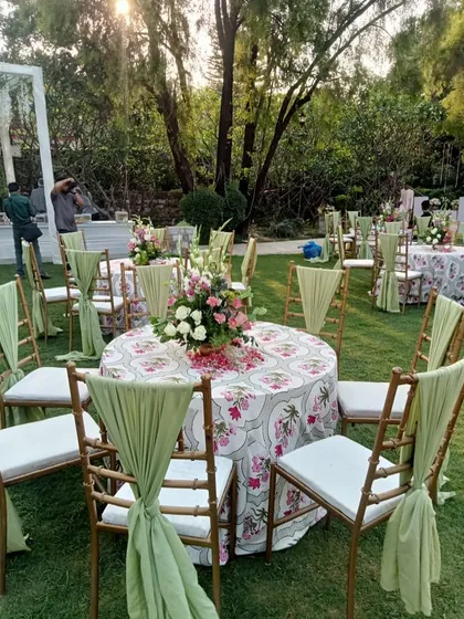 A closer look at the guest seating, with round tables, beautiful floral centerpieces, and elegantly draped chairs.