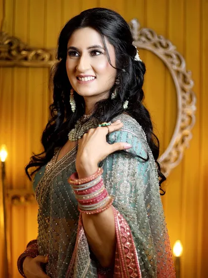A beautiful, smiling portrait of the bride-to-be, capturing her happiness and the warm, festive ambiance of the engagement ceremony.