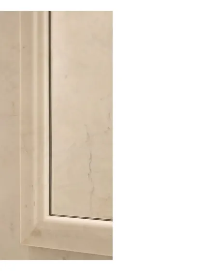 A detail of a marble door frame. The careful shaping of the stone shows our commitment to craft, where every junction and surface is considered to create a complete and harmonious design.