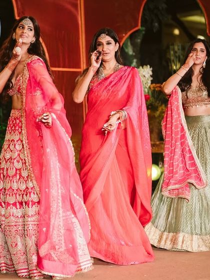 The bride and her sisters striking a pose during their 'Pyaar Da Pind' themed sangeet performance. A beautiful moment of sisterly love.