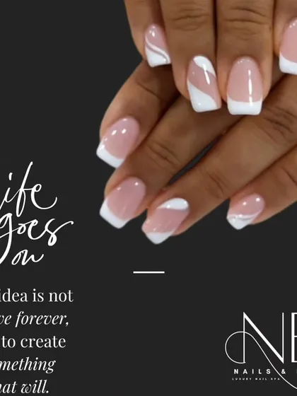A creative take on the classic French manicure. This design uses abstract white swirls and shapes on a sheer nude base for a modern and artistic feel.