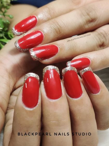 A festive and glamorous French manicure. This set pairs classic red nails with a sparkling glitter French effect on the tips, perfect for holidays and special occasions.
